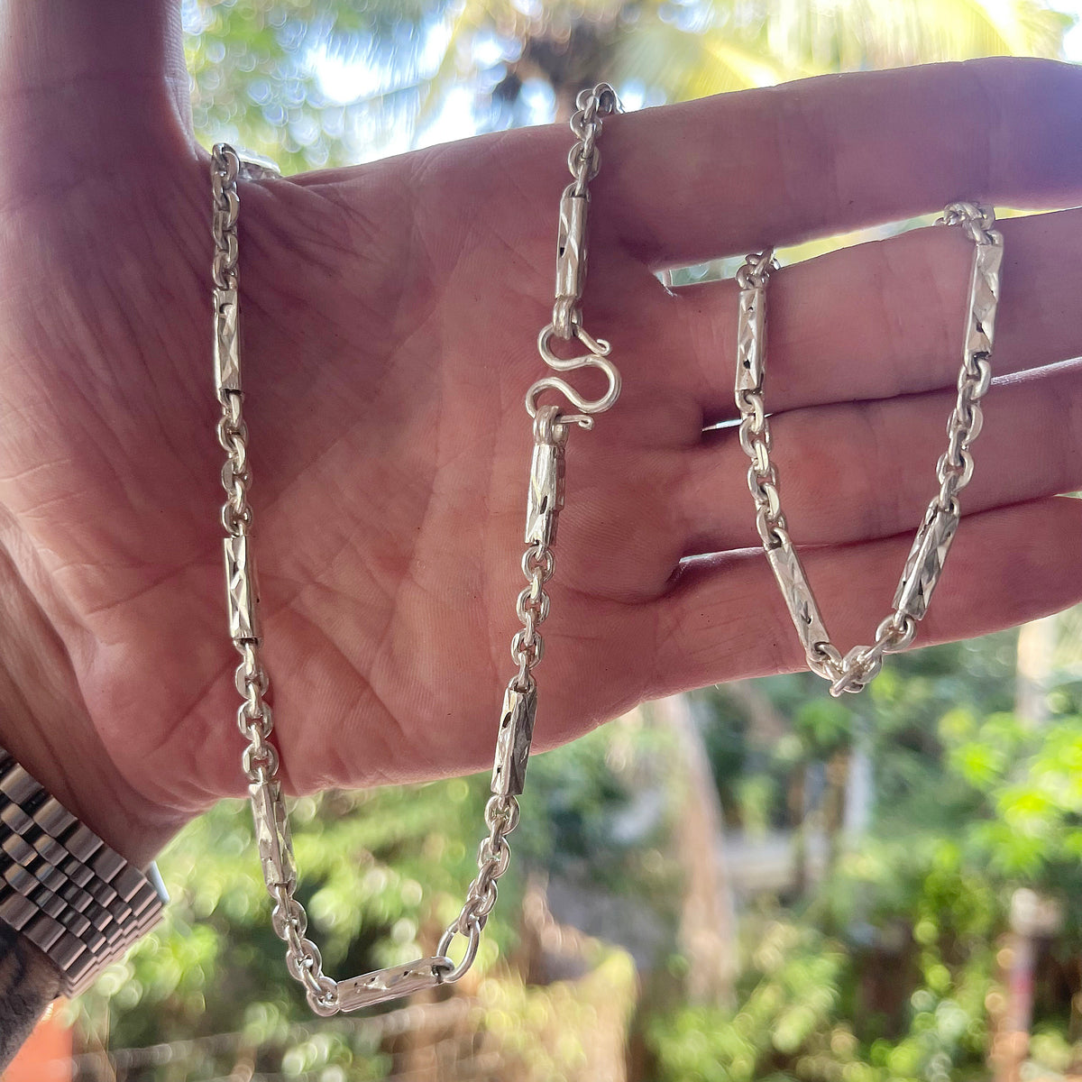 Solid silver Khmer sugarcane chain for men held in hand for scale