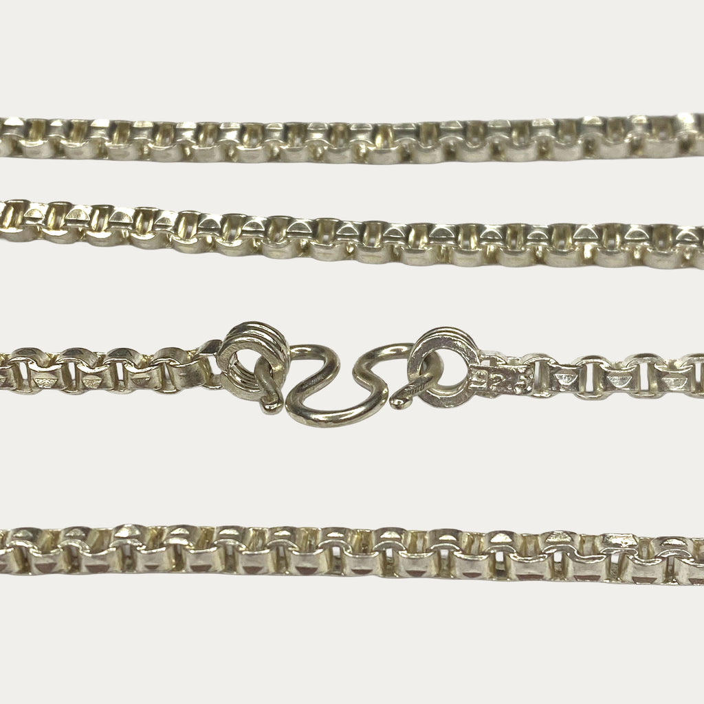 Close-up of solid silver box chain M clasp and links with hallmark