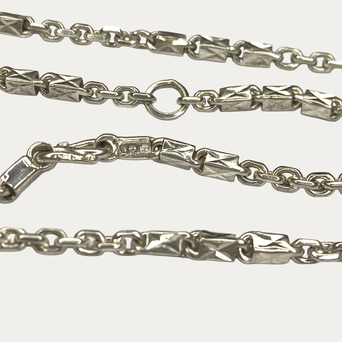 Macro close-up of silver chain hallmark with Triple Bar Khmer Sugarcane link design